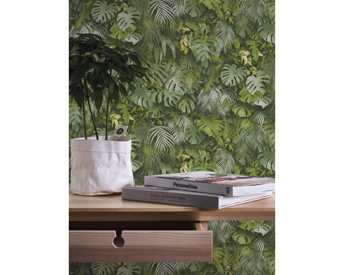 Mur décoratif avec motif végétal, table avec plante et livres