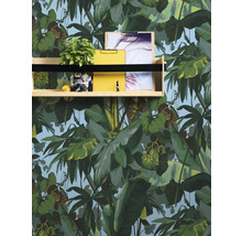 Étagère avec plante, citron, photo et presse-papier jaune devant un papier peint botanique