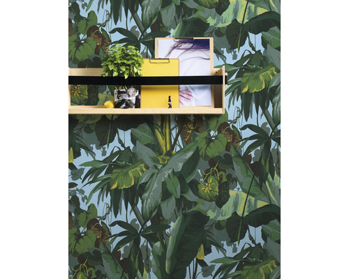 Étagère avec plante, citron, photo et presse-papier jaune devant un papier peint botanique