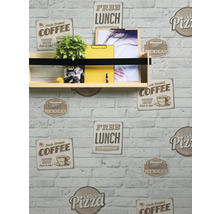 Étagère murale avec plante, bloc-notes jaune et photos sur un mur avec du papier peint à motif de pierres.