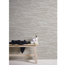 Scène avec un papier peint mural structuré à effet pierre et une table en bois avec des accessoires de salle de bain.