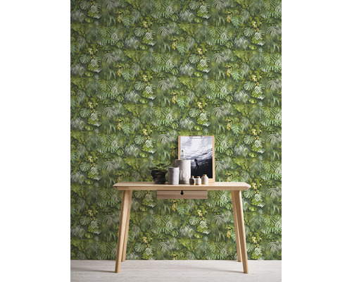 Papier peint photo avec motif de feuilles derrière une table en bois