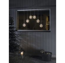 Fenêtre décorative avec guirlande lumineuse de flocons de neige, lanterne et panier avec du bois