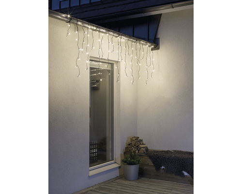 Aussenansicht eines Hauses mit beleuchteter Eisregenlichterkette über einem Fenster