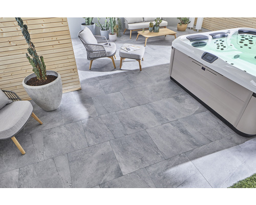 Terrasse mit grauen Steinzeugfliesen, Whirlpool und Sitzmöbeln