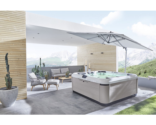 Whirlpool auf einer Terrasse mit Gartenmöbeln und Sonnenschirm