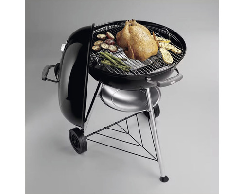 Kugelgrill mit Grillgut wie Hähnchen, Kartoffeln und Spargel