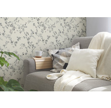 Salon avec canapé gris, coussins et papier peint floral
