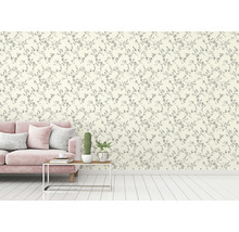 Un salon avec un canapé et un mur avec du papier peint à fleurs