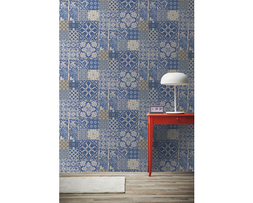 Pièce avec papier peint à motifs patchwork, table rouge et lampe