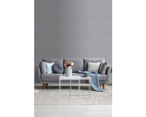 Salon avec papier peint à motifs gris, canapé, tapis et table