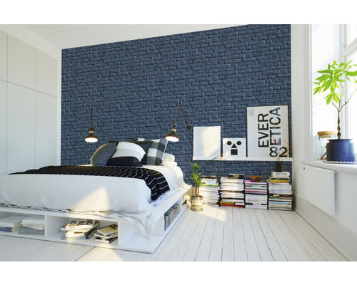 Chambre à coucher avec lit devant un papier peint mural à motif de briques