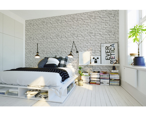 Chambre à coucher avec lit, table de chevet et papier peint imitation briques