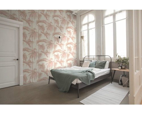 Helles Schlafzimmer mit Bett und Wandtapete mit Palmenmuster