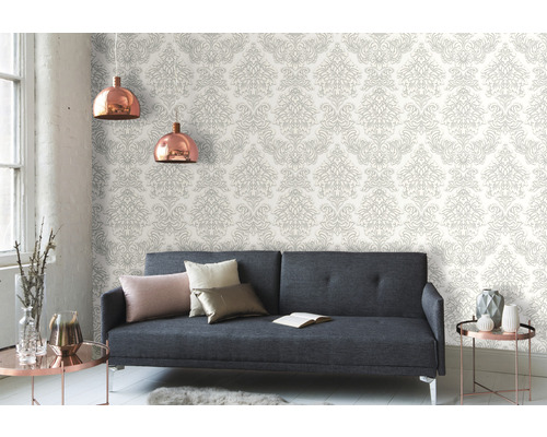 Salon avec canapé gris et papier peint à motifs