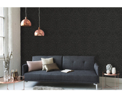 Salon avec canapé gris, papier peint à motifs et deux suspensions