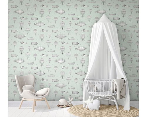 Chambre d''enfant avec papier peint sur le thème de l''aviation, fauteuil et lit de bébé