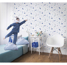 Chambre d''enfant avec papier peint sur le thème de l''espace, lit et enfant jouant en costume d''astronaute