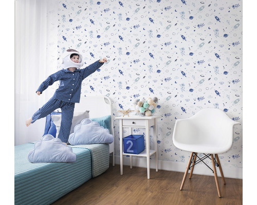 Chambre d''enfant avec papier peint sur le thème de l''espace, lit et enfant jouant en costume d''astronaute