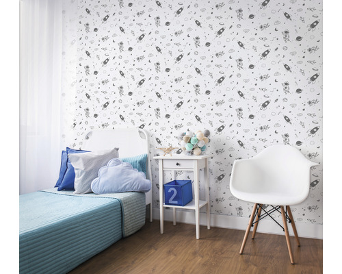 Chambre d''enfant décorée avec papier peint sur le thème de l''espace, lit, table de chevet et chaise