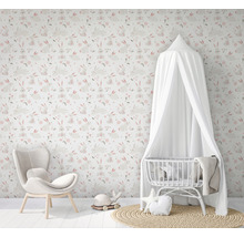 Chambre d''enfant avec papier peint à motifs de lapins, fauteuil et lit de bébé avec baldaquin.