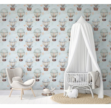 Chambre d''enfant avec papier peint montgolfière, fauteuil et lit de bébé avec baldaquin