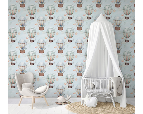 Chambre d''enfant avec papier peint montgolfière, fauteuil et lit de bébé avec baldaquin