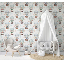 Chambre avec couffin, fauteuil et papier peint à motifs de montgolfières