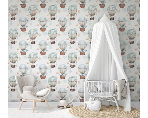 Chambre avec couffin, fauteuil et papier peint à motifs de montgolfières