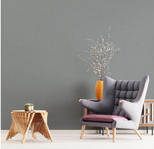 Wohnzimmer-Szene mit Sessel, Beistelltisch, Vase und passender Wandtapete