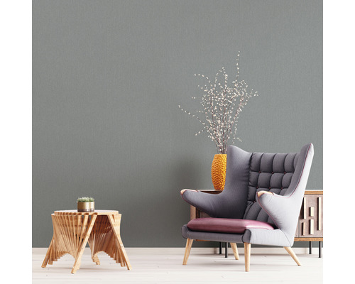 Wohnzimmer-Szene mit Sessel, Beistelltisch, Vase und passender Wandtapete