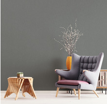 Wohnraum mit grauer Tapete, Sessel und Beistelltisch