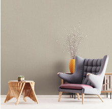 Wohnzimmer mit beiger Tapete, Sessel und Holztisch