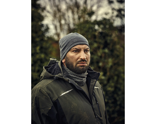 Mann mit Mütze und Arbeitsjacke im Aussenbereich