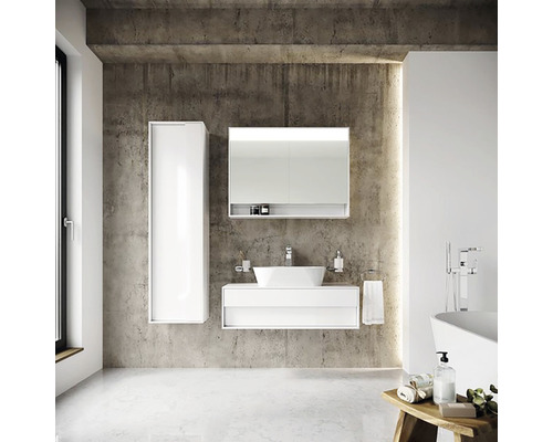 Modernes Badezimmer mit weißem Waschtisch, Spiegelschrank und Hochschrank vor Betonwand