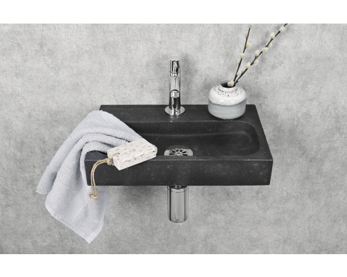 Lavabo en pierre avec robinetterie, serviette et savon