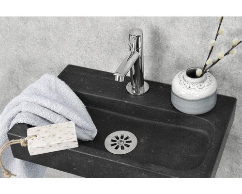 Lavabo en pierre avec robinet, serviette, savon et vase