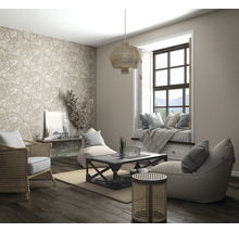 Salon avec meubles en rotin, papier peint à motifs, coin fenêtre et parquet pour une atmosphère lumineuse et organisée.