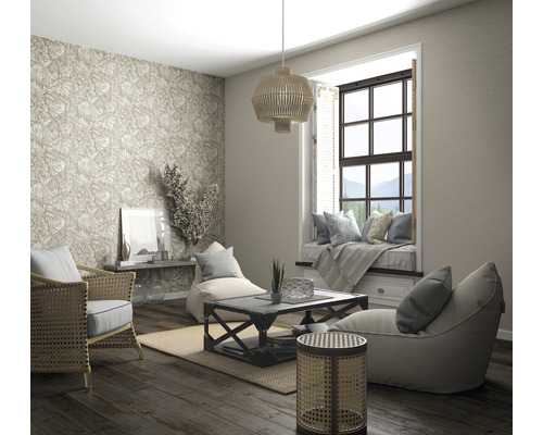 Salon avec meubles en rotin, papier peint à motifs, coin fenêtre et parquet pour une atmosphère lumineuse et organisée.