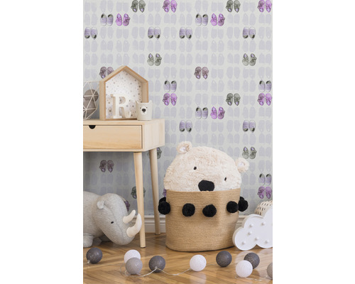 Chambre d''enfant avec table de chevet, peluche et éclairage décoratif devant un papier peint à motif de chaussure.