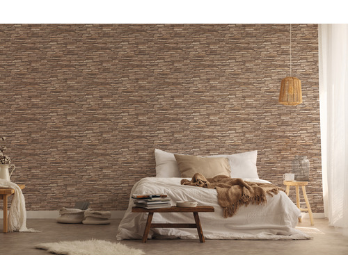 Schlafzimmer mit einer Wand, die mit einer Tapete in Steinoptik gestaltet ist