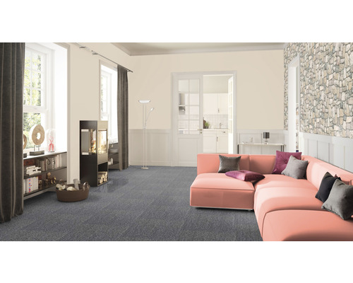 Wohnzimmer mit graublauem Teppichboden, Ecksofa, Kaminofen und Bücherregal