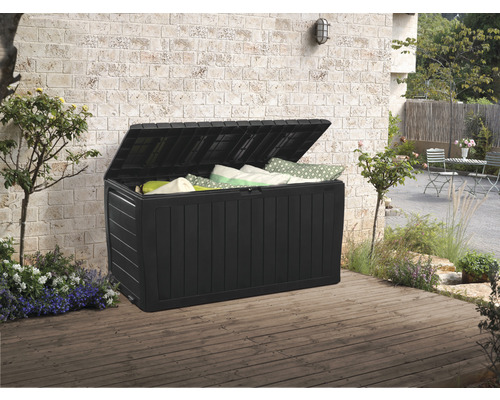 Geöffnete Gartenbox aus Kunststoff mit Kissen im Aussenbereich auf einer Holzterrasse