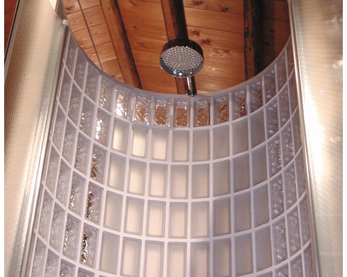 Gebogene Dusche mit Glasbausteinen und Duschkopf