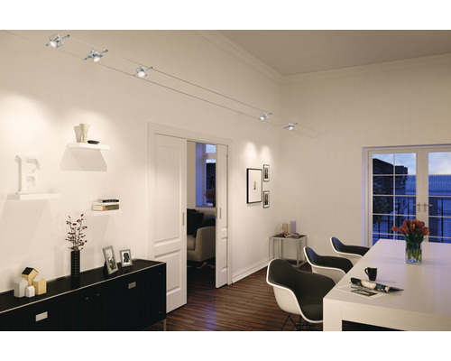 Salon avec porte coulissante, étagères, commode, table à manger, chaises et système d''éclairage sur câble