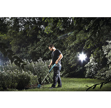 Un homme utilise un coupe-bordure dans le jardin.