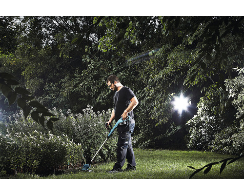 Un homme utilise un coupe-bordure dans le jardin.
