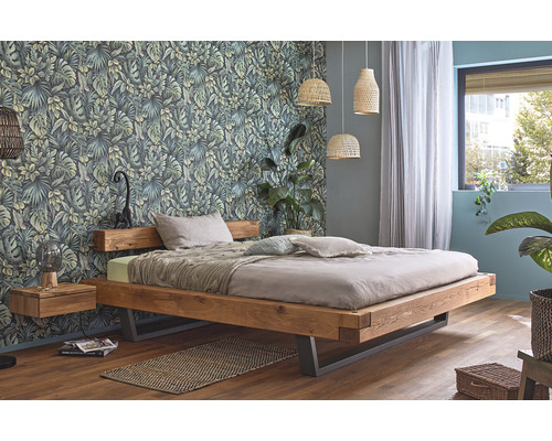 Chambre avec lit en bois, table de chevet et papier peint botanique