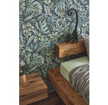 Chambre avec papier peint jungle, lit en bois et table de chevet