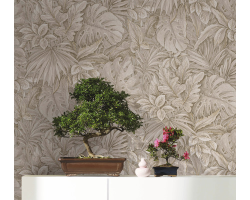 Deux bonsaïs sur une armoire devant un mur avec du papier peint à motifs de feuilles.